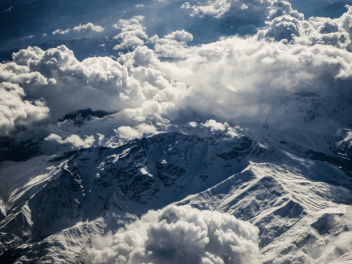 Снежные вершины в клубящихся облаках